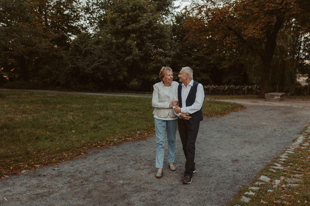 Oma und Opa couple shooting in Weißensee direkt am See. Paarfotos zum 65. Hochzeitstag mit alten Händen und Eheringen. beim spazieren gehen mit der Familie im grünen auf einer wiese.