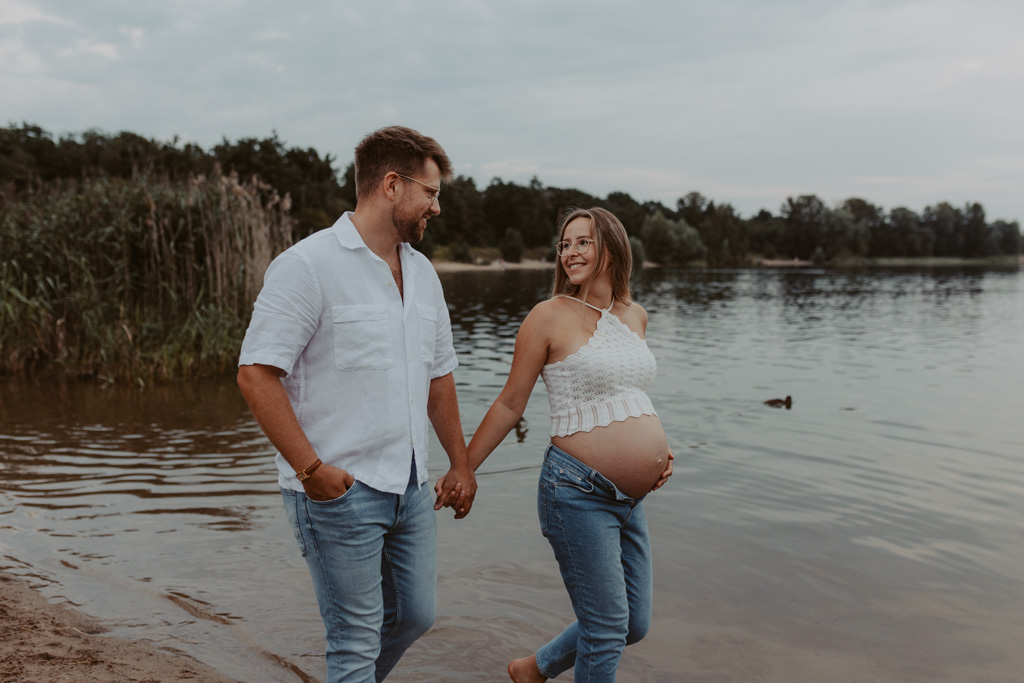 Babybauchfotos in Kaulsdorf in berlin am See und wir waren wieder im grünen in der Natur und haben ganz tolle fotos gemacht am Wasser und am Strand, sowie auf der wiese. es ist ein Paar und die beiden haben ihr erstes Kind erwartet. wir haben ein babybauchshooting gemacht. die sonne ging unter und ich habe fotos von den beiden gamacht. in Bewegung.