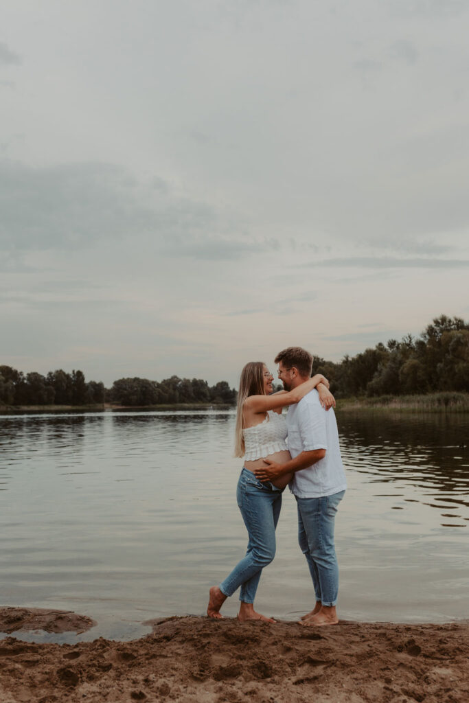Babybauchfotos in Kaulsdorf in berlin am See und wir waren wieder im grünen in der Natur und haben ganz tolle fotos gemacht am Wasser und am Strand, sowie auf der wiese. es ist ein Paar und die beiden haben ihr erstes Kind erwartet. wir haben ein babybauchshooting gemacht. die sonne ging unter und ich habe fotos von den beiden gamacht. in Bewegung.
