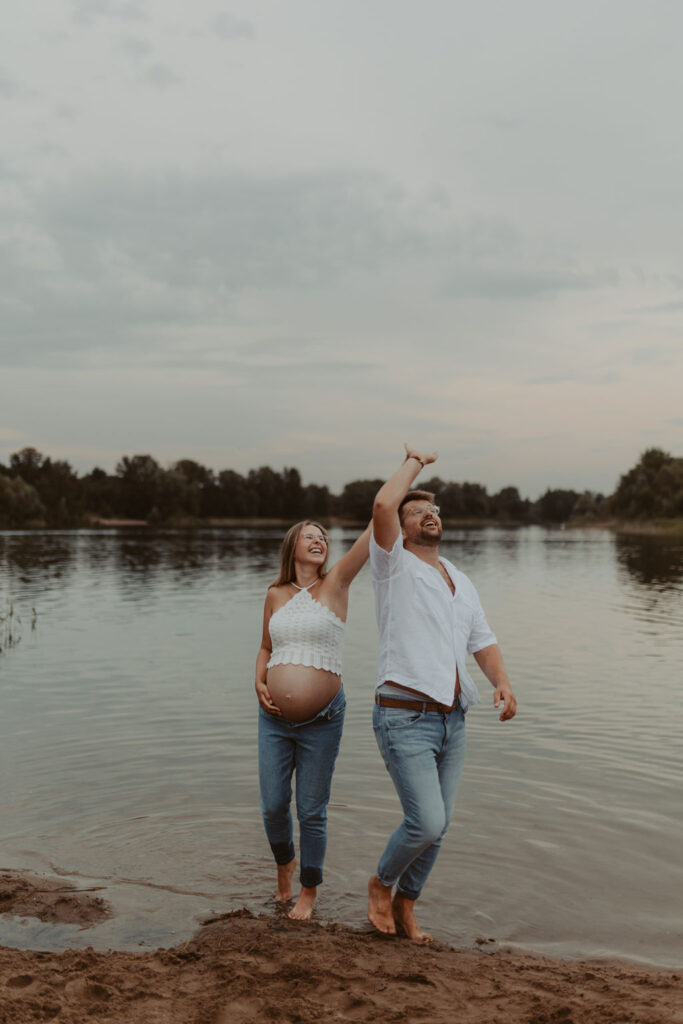 Babybauchfotos in Kaulsdorf in berlin am See und wir waren wieder im grünen in der Natur und haben ganz tolle fotos gemacht am Wasser und am Strand, sowie auf der wiese. es ist ein Paar und die beiden haben ihr erstes Kind erwartet. wir haben ein babybauchshooting gemacht. die sonne ging unter und ich habe fotos von den beiden gamacht. beim tanzen.