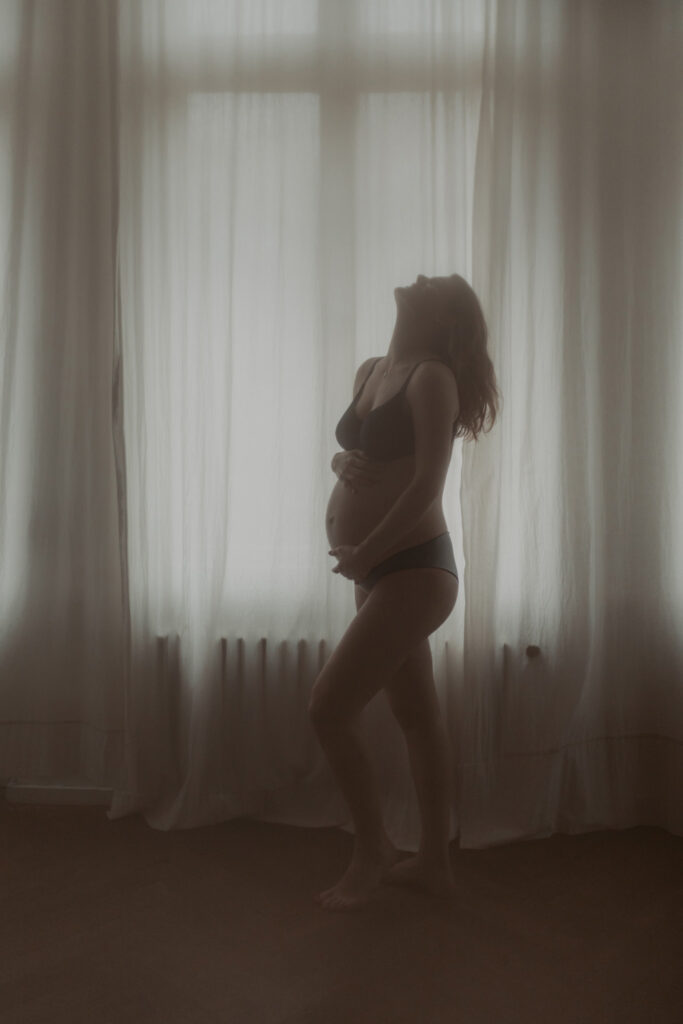 babybauchfotos in einem Tageslichtstudio in pankow in berlin mit einer wunderschönen hochschwangeren Frau mit Babybauch im 9. Monat.