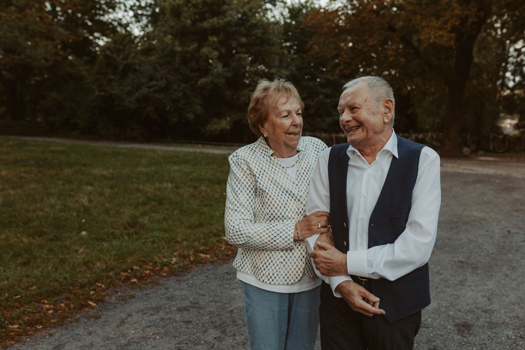 Oma und Opa couple shooting in Weißensee direkt am See. Paarfotos zum 65. Hochzeitstag mit alten Händen und Eheringen. beim spazieren gehen mit der Familie im grünen auf einer wiese.