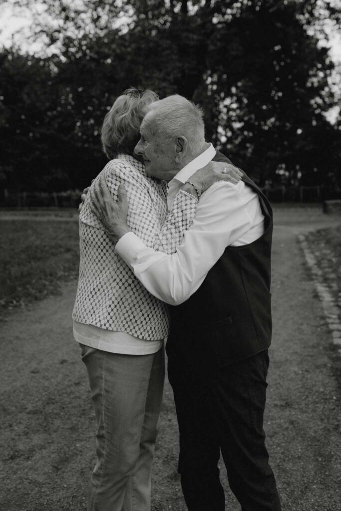 Oma und Opa couple shooting in Weißensee direkt am See. Paarfotos zum 65. Hochzeitstag mit alten Händen und Eheringen. beim spazieren gehen mit der Familie im grünen auf einer wiese.