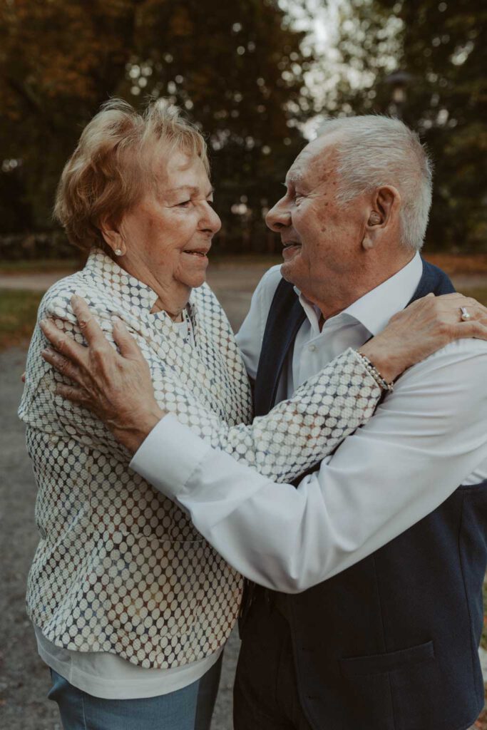 Oma und Opa couple shooting in Weißensee direkt am See. Paarfotos zum 65. Hochzeitstag mit alten Händen und Eheringen. beim spazieren gehen mit der Familie im grünen auf einer wiese.