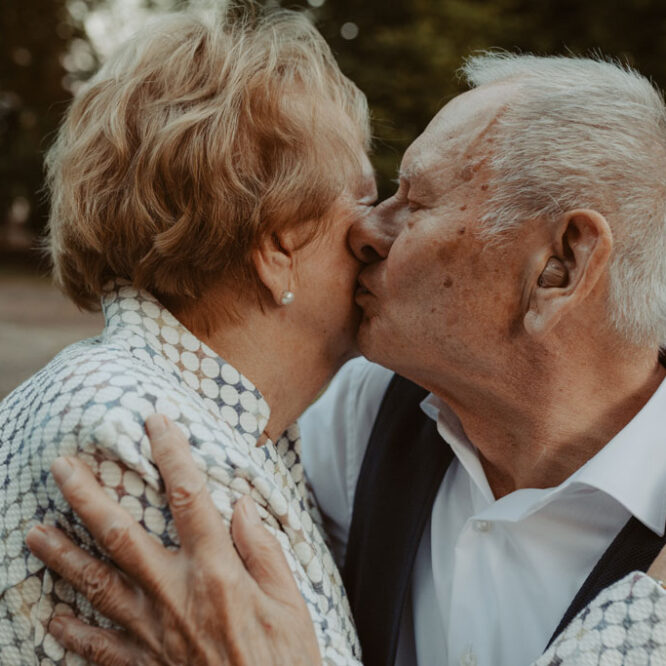 Oma und Opa couple shooting in Weißensee direkt am See. Paarfotos zum 65. Hochzeitstag mit alten Händen und Eheringen. beim spazieren gehen mit der Familie im grünen auf einer wiese.