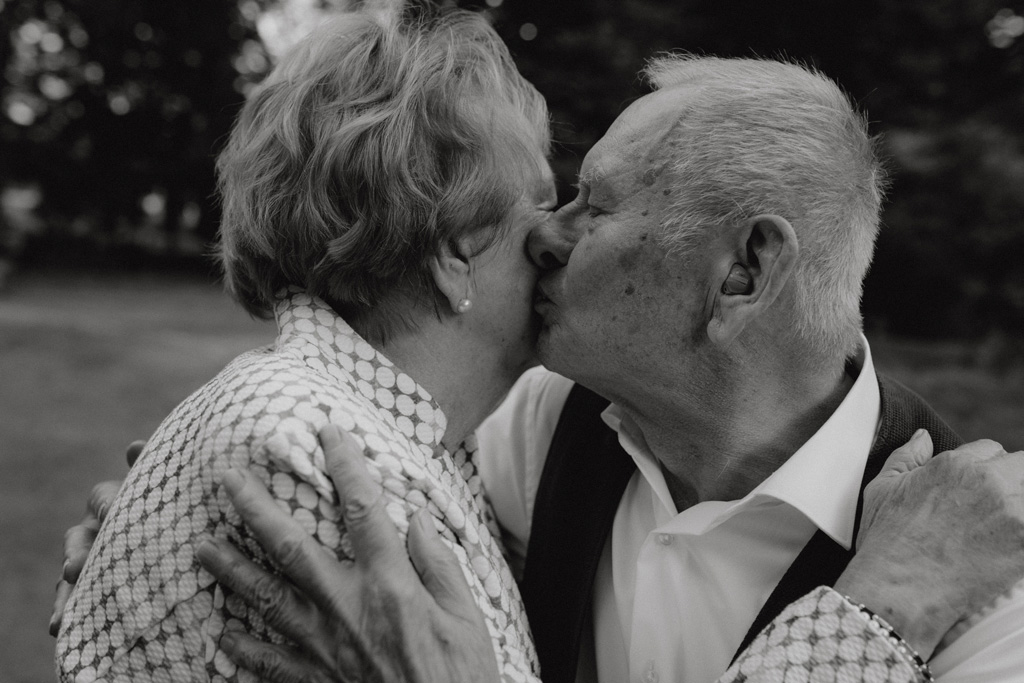 Oma und Opa couple shooting in Weißensee direkt am See. Paarfotos zum 65. Hochzeitstag mit alten Händen und Eheringen. beim spazieren gehen mit der Familie im grünen auf einer wiese.