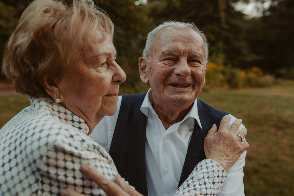 Oma und Opa couple shooting in Weißensee direkt am See. Paarfotos zum 65. Hochzeitstag mit alten Händen und Eheringen. beim spazieren gehen mit der Familie im grünen auf einer wiese.