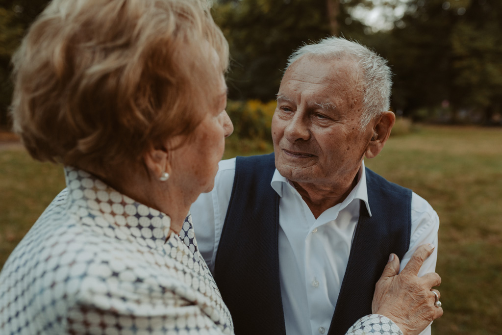 Oma und Opa couple shooting in Weißensee direkt am See. Paarfotos zum 65. Hochzeitstag mit alten Händen und Eheringen. beim spazieren gehen mit der Familie im grünen auf einer wiese.