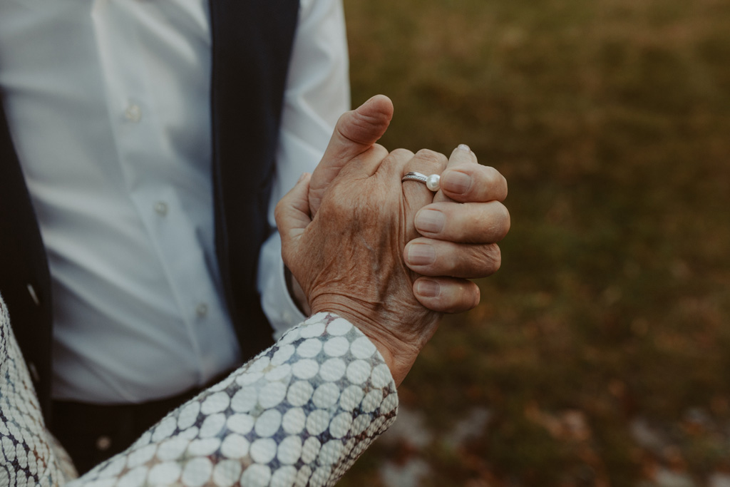 Oma und Opa couple shooting in Weißensee direkt am See. Paarfotos zum 65. Hochzeitstag mit alten Händen und Eheringen. beim spazieren gehen mit der Familie im grünen auf einer wiese.